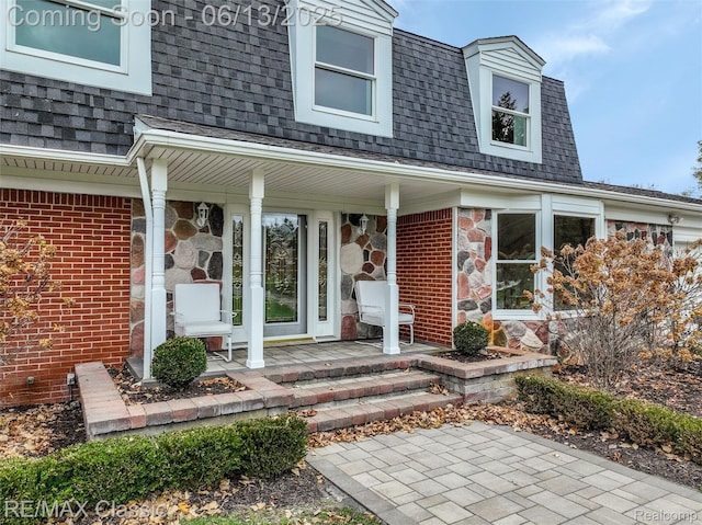 8173 Earhart Rd, South Lyon, MI 48178 - doorway to property featuring covered porch, roof with shingles, and stone siding