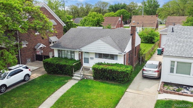 16752 Stricker Ave, Eastpointe, MI 48021 - bungalow-style home with a front yard, a shingled roof, and brick siding