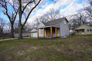 2924 Austin St, Muskegon, MI 49444 - view of front of house with covered porch, a detached garage, and a front yard