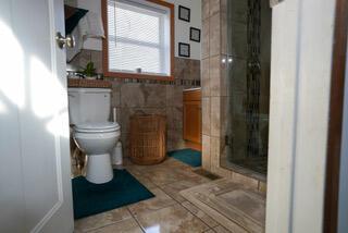 2924 Austin St, Muskegon, MI 49444 - full bathroom with a stall shower, toilet, vanity, tile walls, and tile patterned flooring