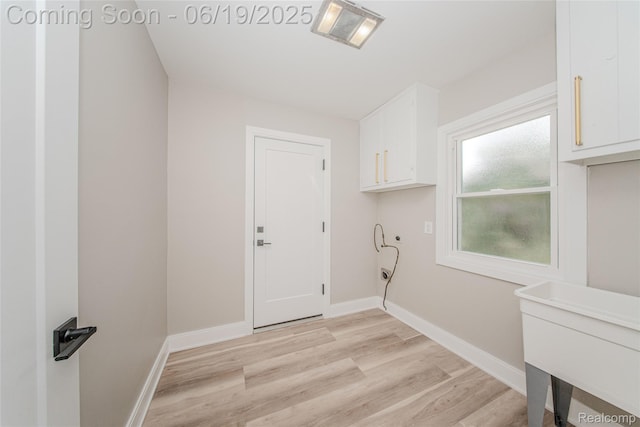 21993 Riverview Dr, Bloomfield Hills, MI 48025 - laundry room featuring light wood-type flooring and cabinet space