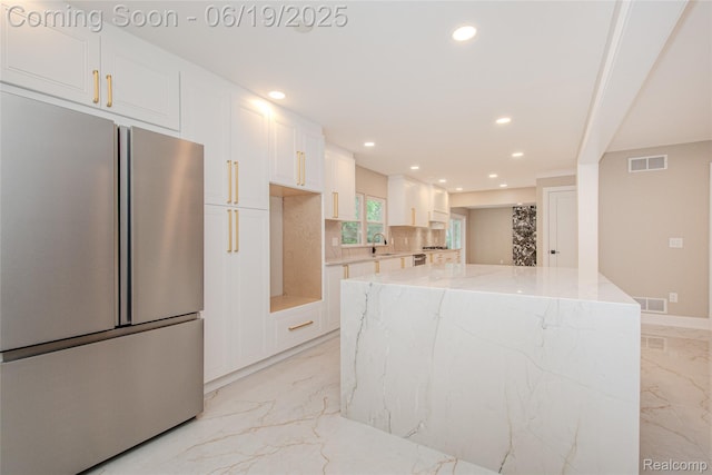 21993 Riverview Dr, Bloomfield Hills, MI 48025 - kitchen featuring freestanding refrigerator, light marble finish floors, recessed lighting, white cabinetry, and light stone counters