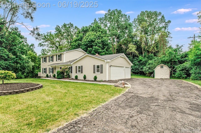 21993 Riverview Dr, Bloomfield Hills, MI 48025 - view of front facade featuring an attached garage, a storage unit, driveway, a front lawn, and view of wooded area