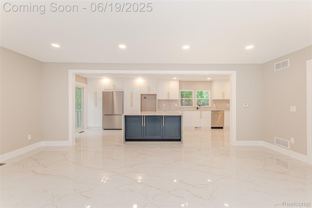 21993 Riverview Dr, Bloomfield Hills, MI 48025 - kitchen with appliances with stainless steel finishes, white cabinetry, light marble finish flooring, recessed lighting, and a center island