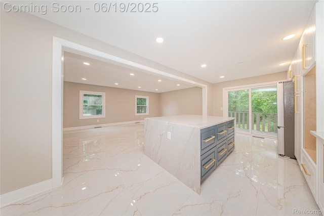 21993 Riverview Dr, Bloomfield Hills, MI 48025 - kitchen with light marble finish flooring, freestanding refrigerator, recessed lighting, light stone counters, and white cabinetry