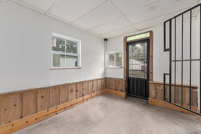 15377 Heyden St, Detroit, MI 48223 - empty room with a paneled ceiling, wainscoting, concrete floors, and wooden walls