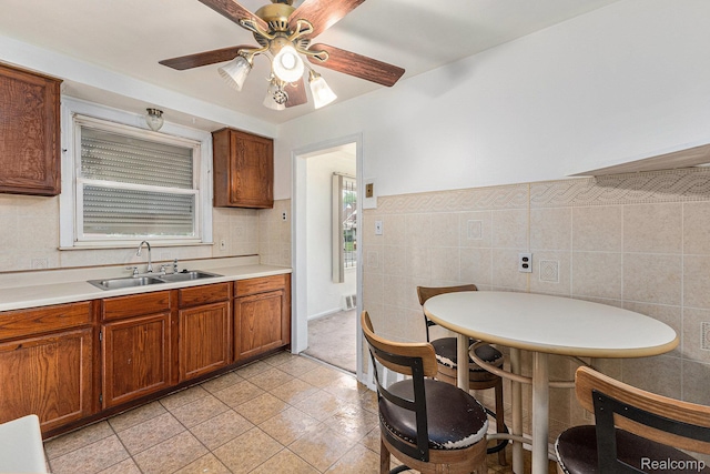 15377 Heyden St, Detroit, MI 48223 - kitchen featuring a sink, brown cabinetry, tile walls, light countertops, and ceiling fan
