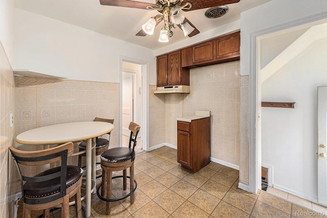 15377 Heyden St, Detroit, MI 48223 - kitchen featuring tile walls, ceiling fan, light countertops, light tile patterned flooring, and brown cabinets