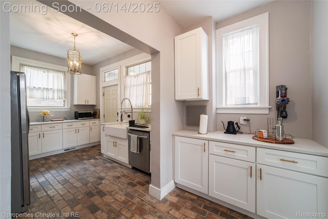 8604 La Salle Blvd, Detroit, MI 48206 - kitchen featuring appliances with stainless steel finishes, brick patterned flooring, white cabinets, a chandelier, and decorative light fixtures