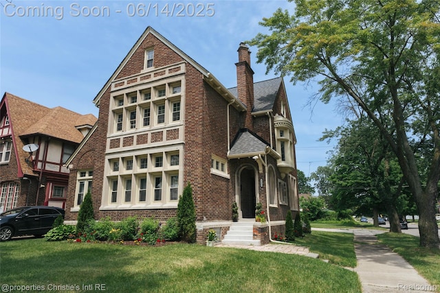 8604 La Salle Blvd, Detroit, MI 48206 - view of front of home with brick siding, a chimney, a front yard, and roof with shingles