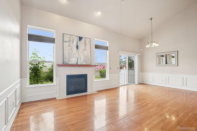 3871 Elvera Ln, Warren, MI 48092 - unfurnished living room with a fireplace with flush hearth, a decorative wall, wainscoting, a chandelier, and light wood-type flooring