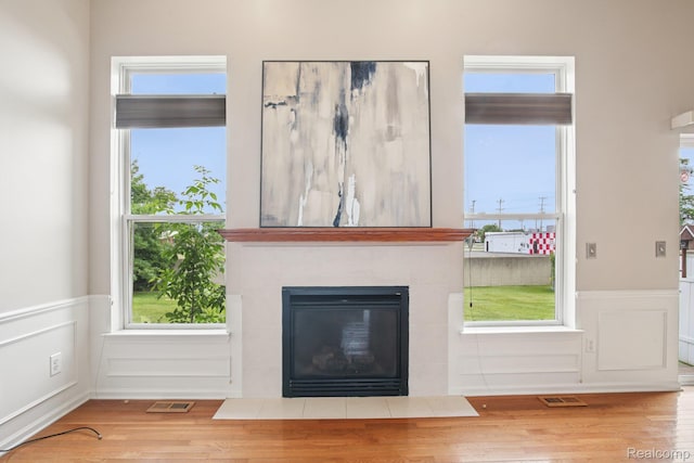 3871 Elvera Ln, Warren, MI 48092 - unfurnished living room featuring a wainscoted wall, wood finished floors, a tiled fireplace, and a decorative wall