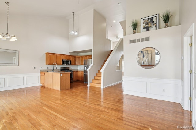 3871 Elvera Ln, Warren, MI 48092 - kitchen featuring stainless steel appliances, a chandelier, high vaulted ceiling, open floor plan, and hanging light fixtures