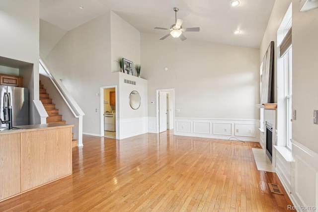 3871 Elvera Ln, Warren, MI 48092 - unfurnished living room with a ceiling fan, high vaulted ceiling, light wood-type flooring, stairway, and a fireplace with flush hearth