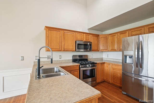 3871 Elvera Ln, Warren, MI 48092 - kitchen featuring stainless steel appliances, wood finished floors, light countertops, brown cabinets, and wainscoting