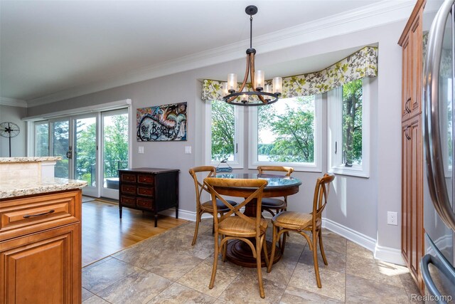 6081 Byram Lake Dr, Linden, MI 48451 - dining space with a chandelier, ornamental molding, and light stone finish floors