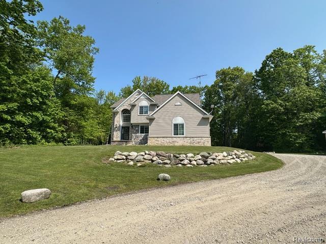 1727 Pero Lake Rd, Lapeer, MI 48446 - view of front of home with stone siding, a front yard, and driveway