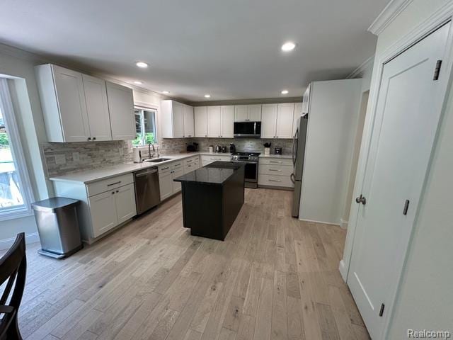 1727 Pero Lake Rd, Lapeer, MI 48446 - kitchen featuring appliances with stainless steel finishes, tasteful backsplash, a center island, light wood finished floors, and ornamental molding
