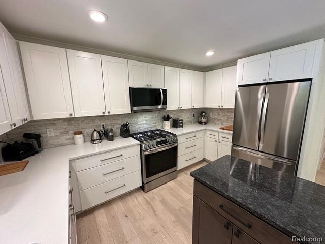 1727 Pero Lake Rd, Lapeer, MI 48446 - kitchen featuring stainless steel appliances, white cabinetry, backsplash, light stone counters, and recessed lighting