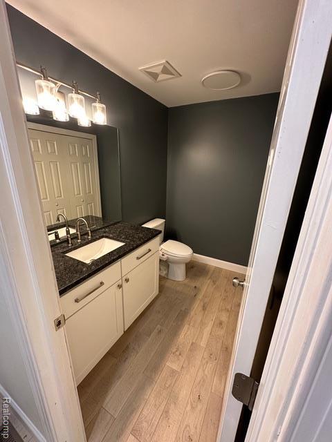 1727 Pero Lake Rd, Lapeer, MI 48446 - bathroom featuring vanity, wood finished floors, toilet, and baseboards