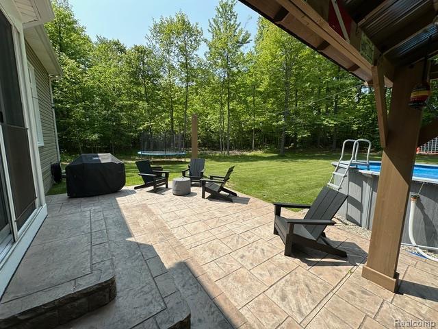 1727 Pero Lake Rd, Lapeer, MI 48446 - view of patio / terrace featuring a trampoline, an outdoor pool, and area for grilling