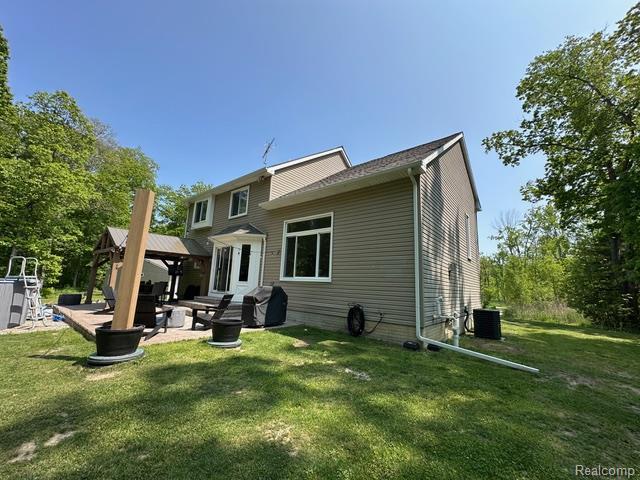 1727 Pero Lake Rd, Lapeer, MI 48446 - back of house featuring a gazebo, a yard, a patio area, and central AC unit