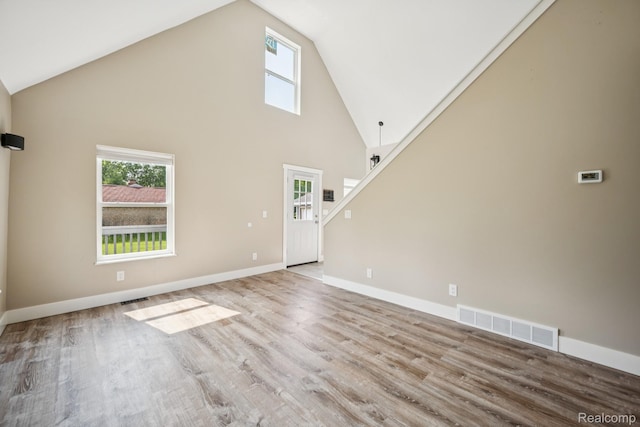 6195 Falkenbury Rd, North Branch, MI 48461 - unfurnished living room featuring high vaulted ceiling, plenty of natural light, wood finished floors, and baseboards