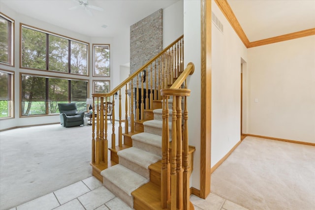 3438 Sandy Shore Dr, Metamora, MI 48455 - staircase featuring carpet flooring, baseboards, tile patterned floors, a high ceiling, and crown molding