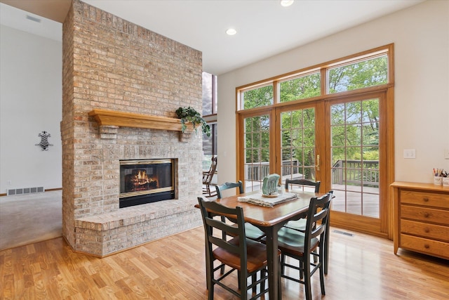 3438 Sandy Shore Dr, Metamora, MI 48455 - dining space featuring wood finished floors, a brick fireplace, and recessed lighting