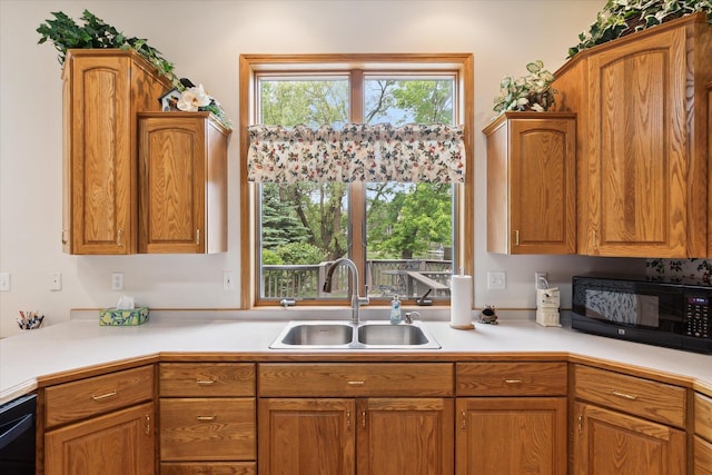 3438 Sandy Shore Dr, Metamora, MI 48455 - kitchen with black appliances, a sink, light countertops, and brown cabinetry