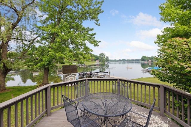 3438 Sandy Shore Dr, Metamora, MI 48455 - wooden deck with a water view, outdoor dining area, a lawn, and a shed