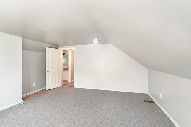 2958 E Stewart Rd, Midland, MI 48640 - additional living space featuring vaulted ceiling, carpet floors, and baseboards