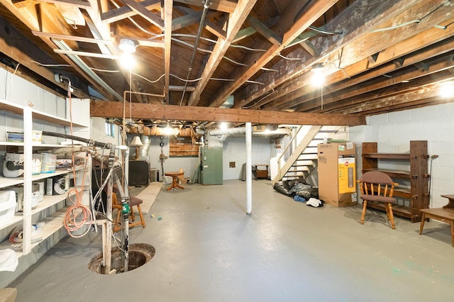 2958 E Stewart Rd, Midland, MI 48640 - unfinished below grade area featuring stairway, heating unit, and concrete block wall