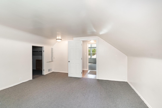2958 E Stewart Rd, Midland, MI 48640 - bonus room featuring dark colored carpet, vaulted ceiling, and baseboards