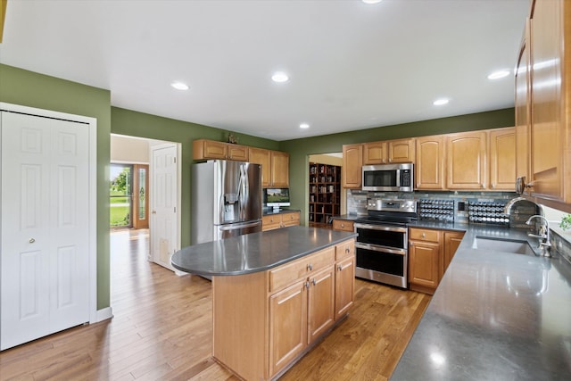 2056 Merlot Ct, Ann Arbor, MI 48108 - kitchen with stainless steel appliances, a sink, a center island, backsplash, and dark countertops