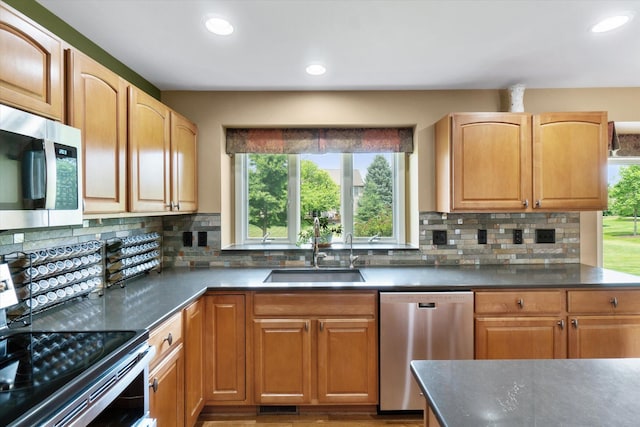 2056 Merlot Ct, Ann Arbor, MI 48108 - kitchen featuring appliances with stainless steel finishes, a sink, healthy amount of natural light, dark countertops, and recessed lighting