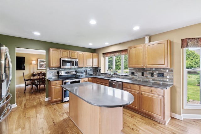 2056 Merlot Ct, Ann Arbor, MI 48108 - kitchen featuring appliances with stainless steel finishes, a sink, tasteful backsplash, a center island, and dark countertops
