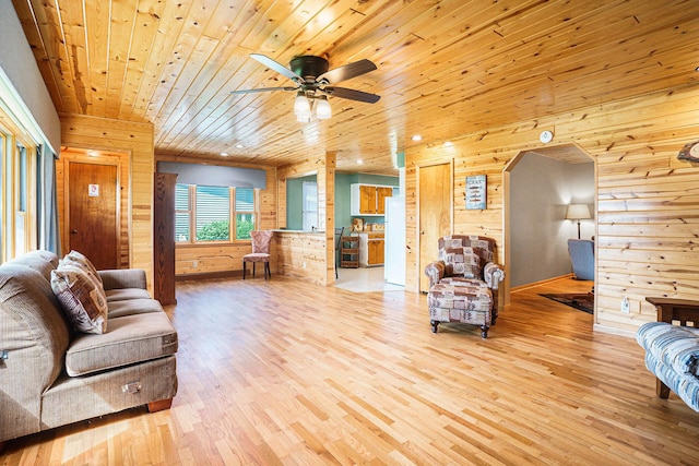 1018 Ruddiman Dr, North Muskegon, MI 49445 - living area featuring wood walls, light wood-style floors, wooden ceiling, a ceiling fan, and arched walkways