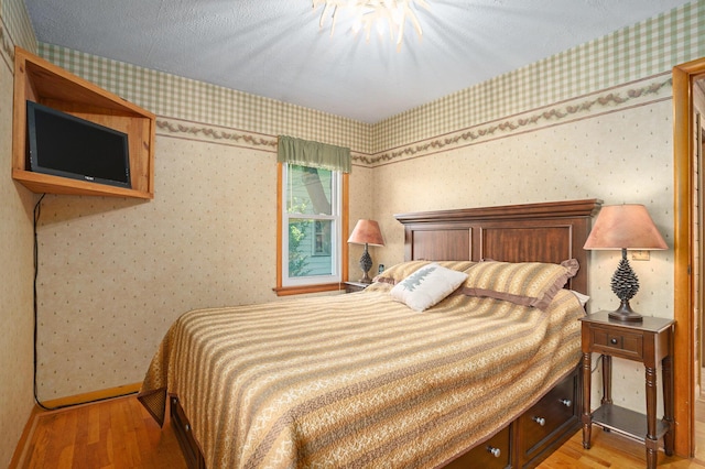 1018 Ruddiman Dr, North Muskegon, MI 49445 - bedroom featuring wood finished floors, wallpapered walls, and baseboards