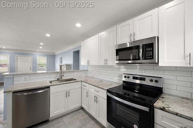 233 W 11 Mile Rd, Madison Heights, MI 48071 - kitchen with stainless steel appliances, a peninsula, white cabinetry, backsplash, and recessed lighting