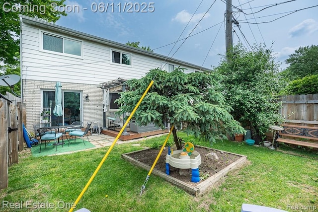104 Manor Way Unit 1, Rochester Hills, MI 48309 - rear view of property featuring a vegetable garden, brick siding, and a patio area