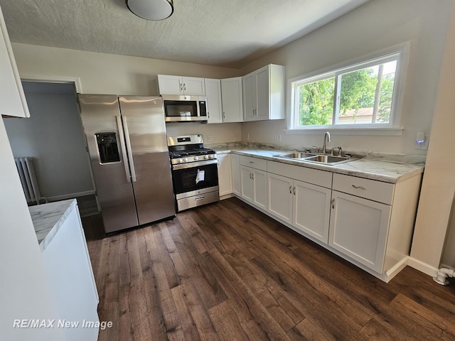 1902 Newberry St, Saginaw, MI 48602 - kitchen featuring appliances with stainless steel finishes, a sink, dark wood-style flooring, white cabinets, and a textured ceiling