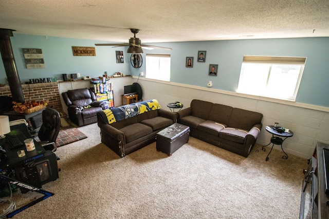 7070 Quain Rd, Birch Run, MI 48415 - living room featuring a wood stove, ceiling fan, a textured ceiling, and carpet flooring