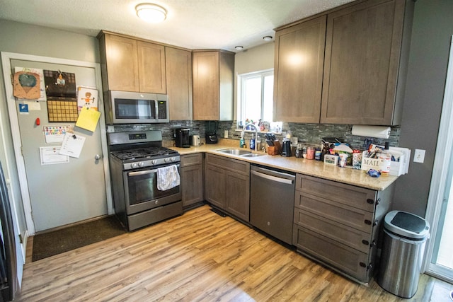 7070 Quain Rd, Birch Run, MI 48415 - kitchen featuring appliances with stainless steel finishes, a sink, tasteful backsplash, light wood finished floors, and light countertops