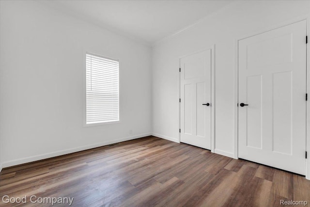 2826 16th St, Detroit, MI 48216 - unfurnished bedroom with multiple windows and wood finished floors