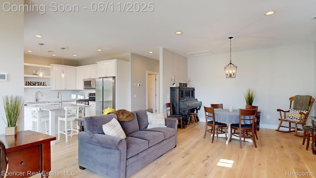 615 Dunleavy Dr, Highland, MI 48356 - living area featuring recessed lighting, light wood-type flooring, a wood stove, and a chandelier