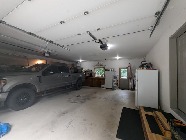 8544 Esmond Rd, Hale, MI 48739 - garage with a garage door opener, freestanding refrigerator, and fridge
