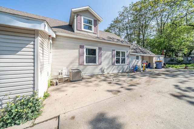 2110 Saint Charles Ave SW, Grand Rapids, MI 49507 - back of property featuring a patio, central AC, and roof with shingles