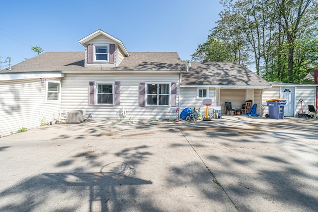 2110 Saint Charles Ave SW, Grand Rapids, MI 49507 - rear view of property featuring roof with shingles, driveway, and central AC