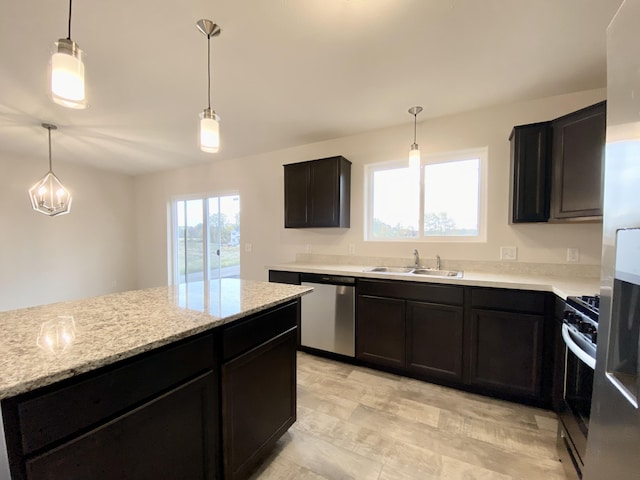 4272 Butternut Dr, Wayland, MI 49348 - kitchen featuring appliances with stainless steel finishes, a sink, hanging light fixtures, light stone countertops, and dark cabinets